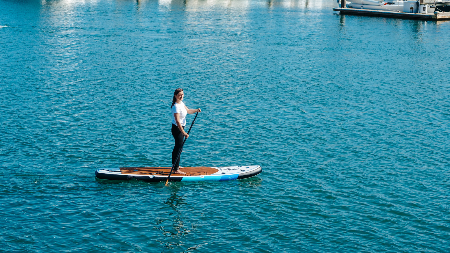 A Woman in White Shirt Riding on Sup Board